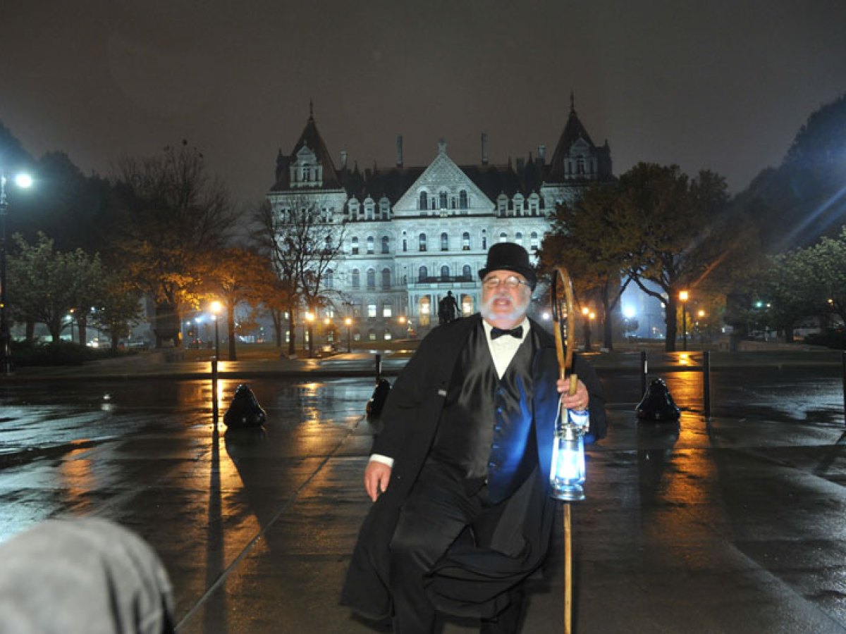 a man in a wet suit standing on a rainy night